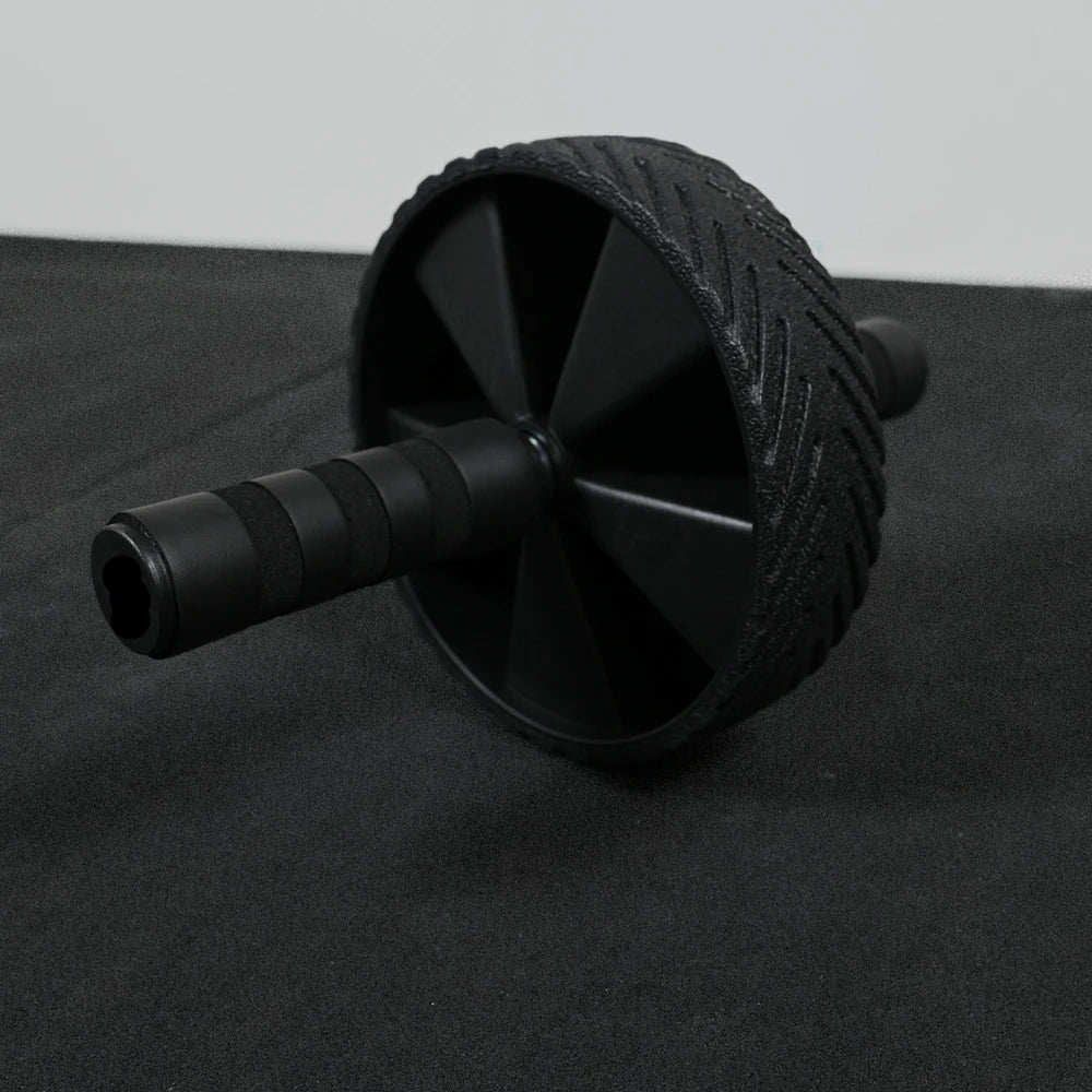 Black ab roller on a black surface with a gray background