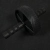 Ab roller with anti slip grip handles on a black floor