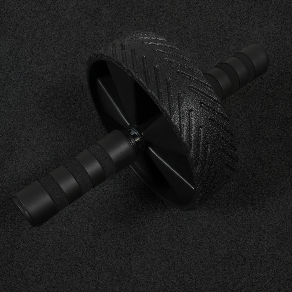 Ab roller with anti slip grip handles on a black floor