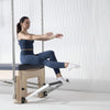 Woman using a Pilates reformer machine in a studio setting