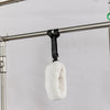 White fur-lined glove pilates reformer attachment on a metal rod against a gray background