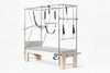 Pilates reformer machine with attachments on a white background