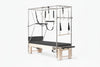 Pilates reformer machine with attachments on a white background
