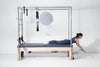 Woman using a pilates reformer machine in a studio setting