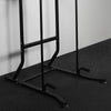 Black metal pull-up bar stand on a dark floor with a light gray wall background