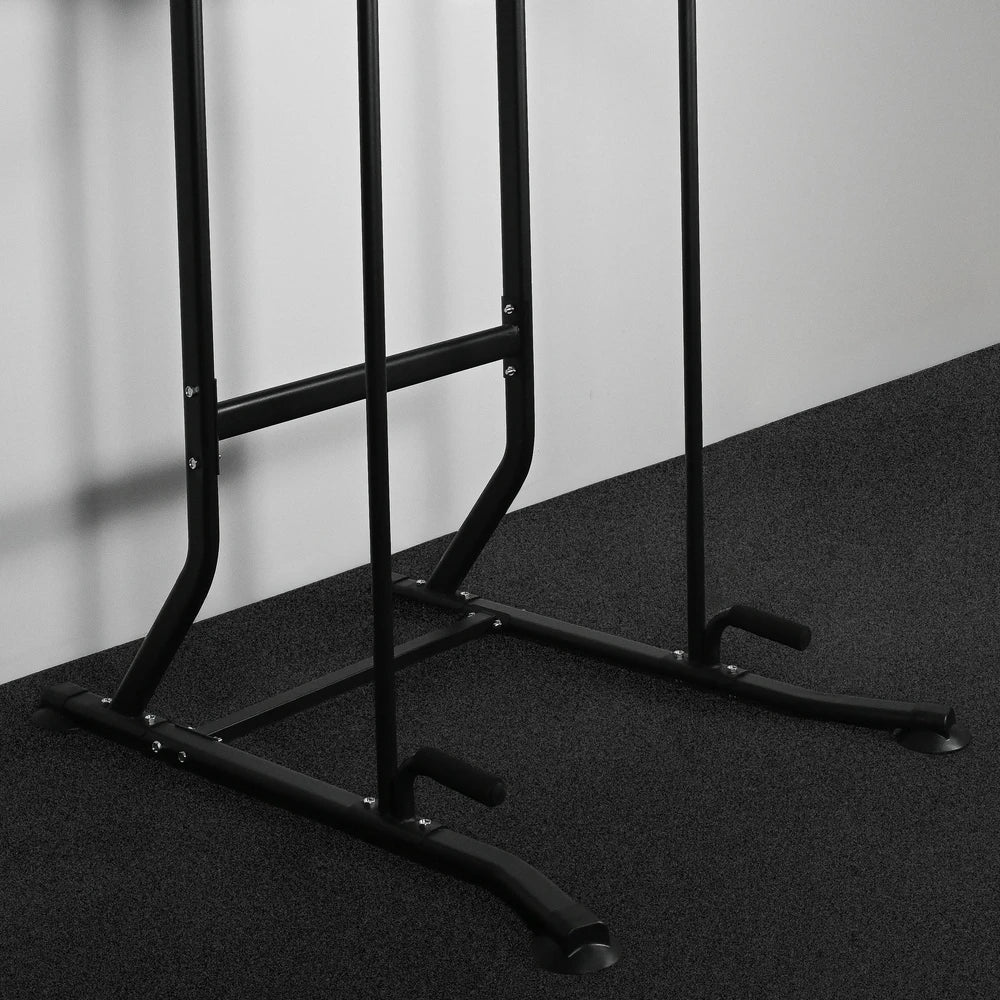 Black metal pull-up bar stand on a dark floor with a light gray wall background
