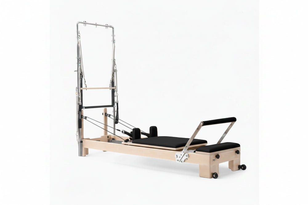 Pilates reformer tower in oak with black seats on a white background