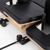 Black padding on an oak pilates reformer machine