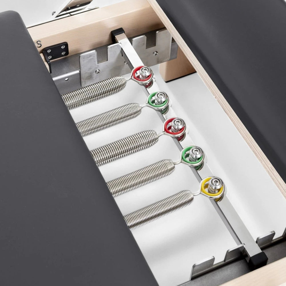Springs of a pilates reformer machine with dark cushion seats