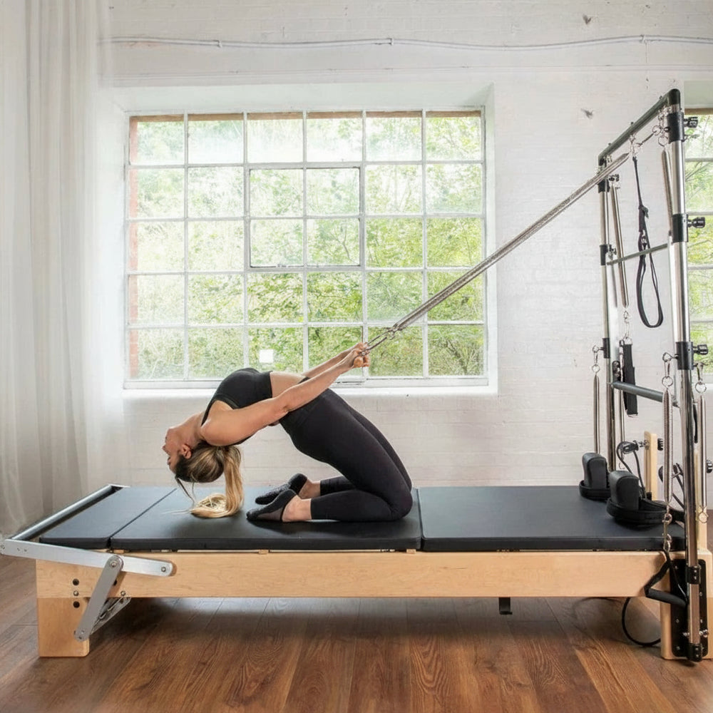 Woman using a pilates reformer in a home gym setting