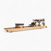 Wooden water rowing machine with black seat on a white background