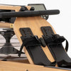 Wooden rowing machine with black seat straps on a white background