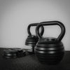 Weight plates from an adjustable kettlebell on a dark background