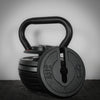 Black kettlebell with adjustable weight options on a dark background