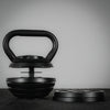 Adjustable kettlebell with 2 plates removed on a dark background