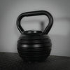 Single black adjustable kettlebell on a dark background