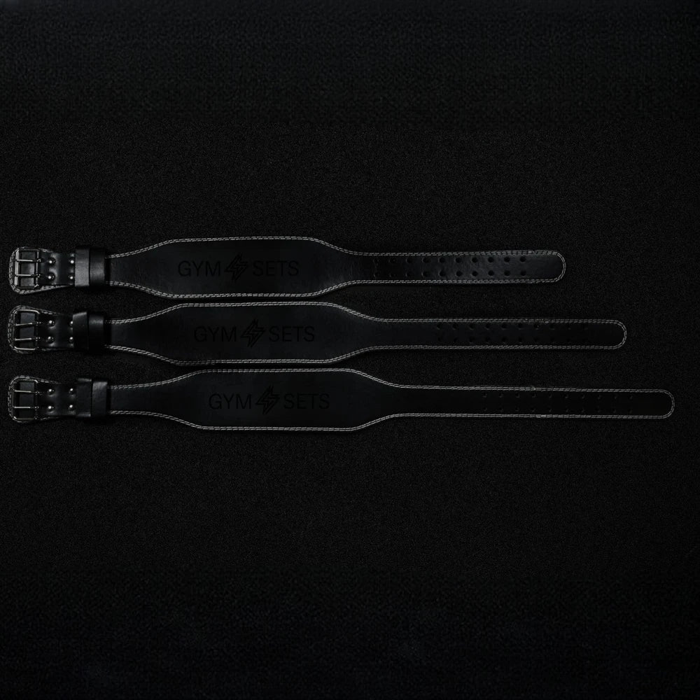 Different size leather weight lifting straps on a dark background