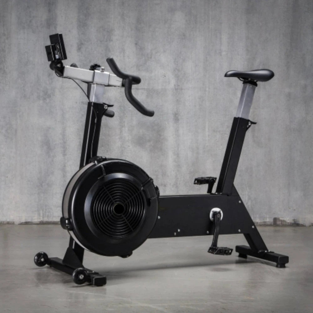 Black exercise bike against a gray concrete wall.
