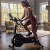 Woman using an air resistance bike in a home gym setting