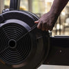 Hand interacting with a black exercise bike