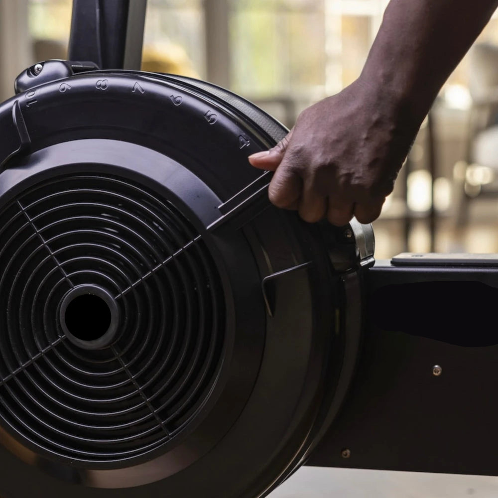 Hand interacting with a black exercise bike