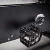 Close-up of a black pedal mechanism on an exercise bike on a dark background