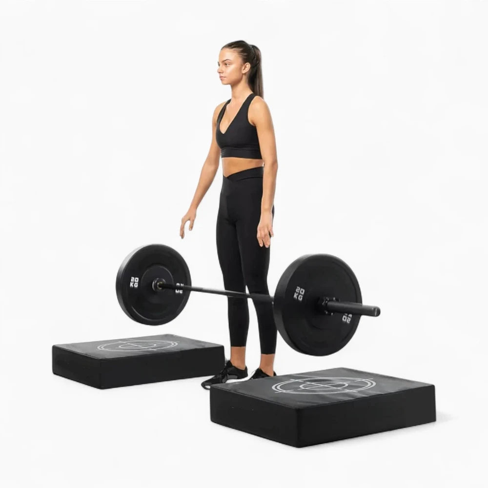 Woman dropping barbell onto drop pads on a white background