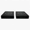 Two black square weight drop pads with target designs on a white background