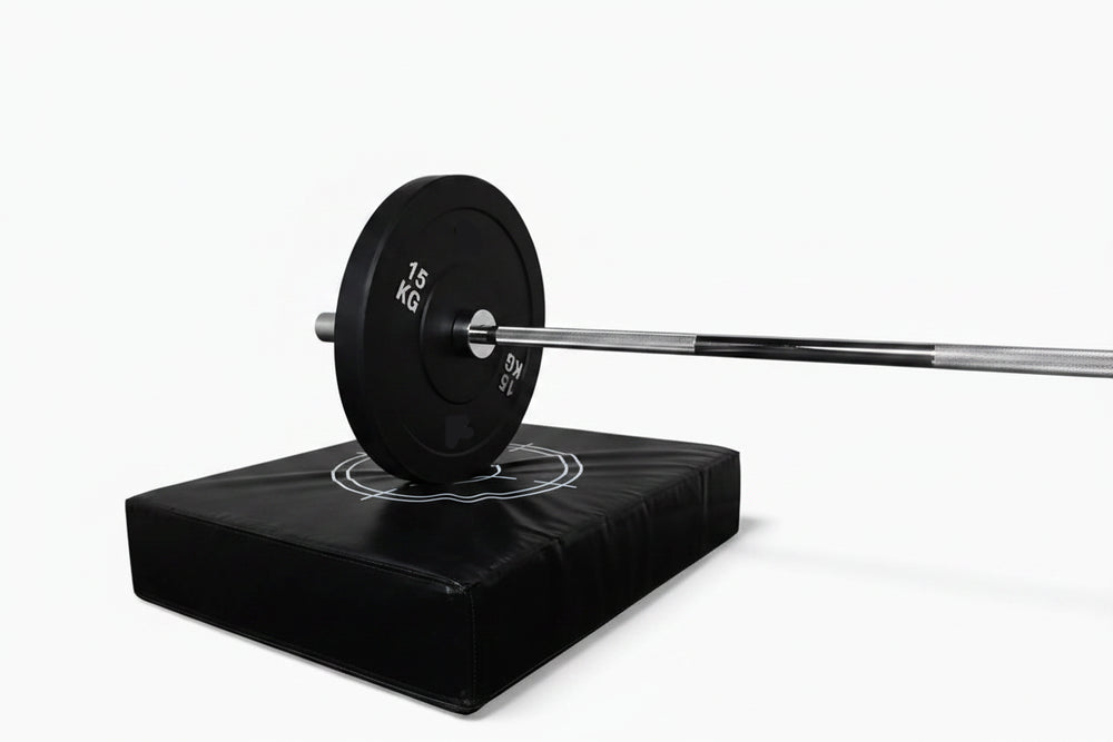 Barbell with weight plate on a black drop pad against a white background