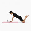 Woman using a pilates reformer board on a white background