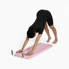 Person using a pink pilates board with a white background