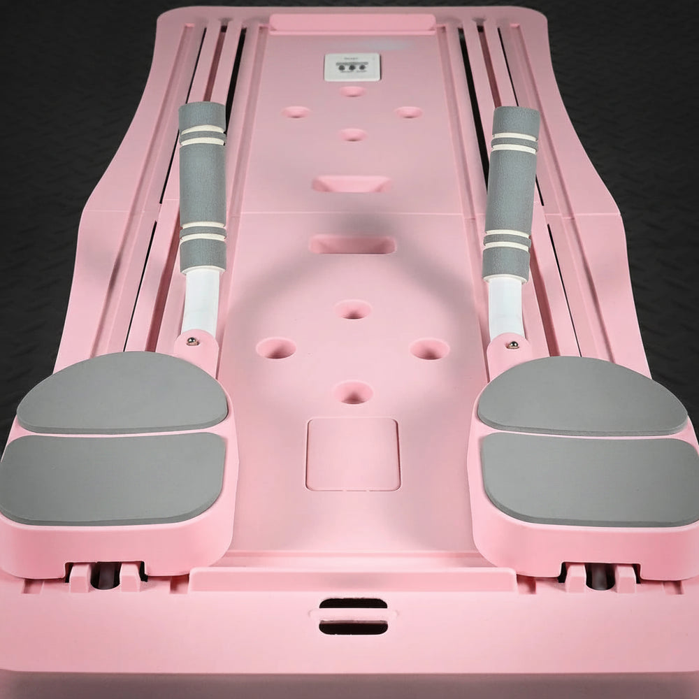Pink and gray pilates reformer exercise board on a black background