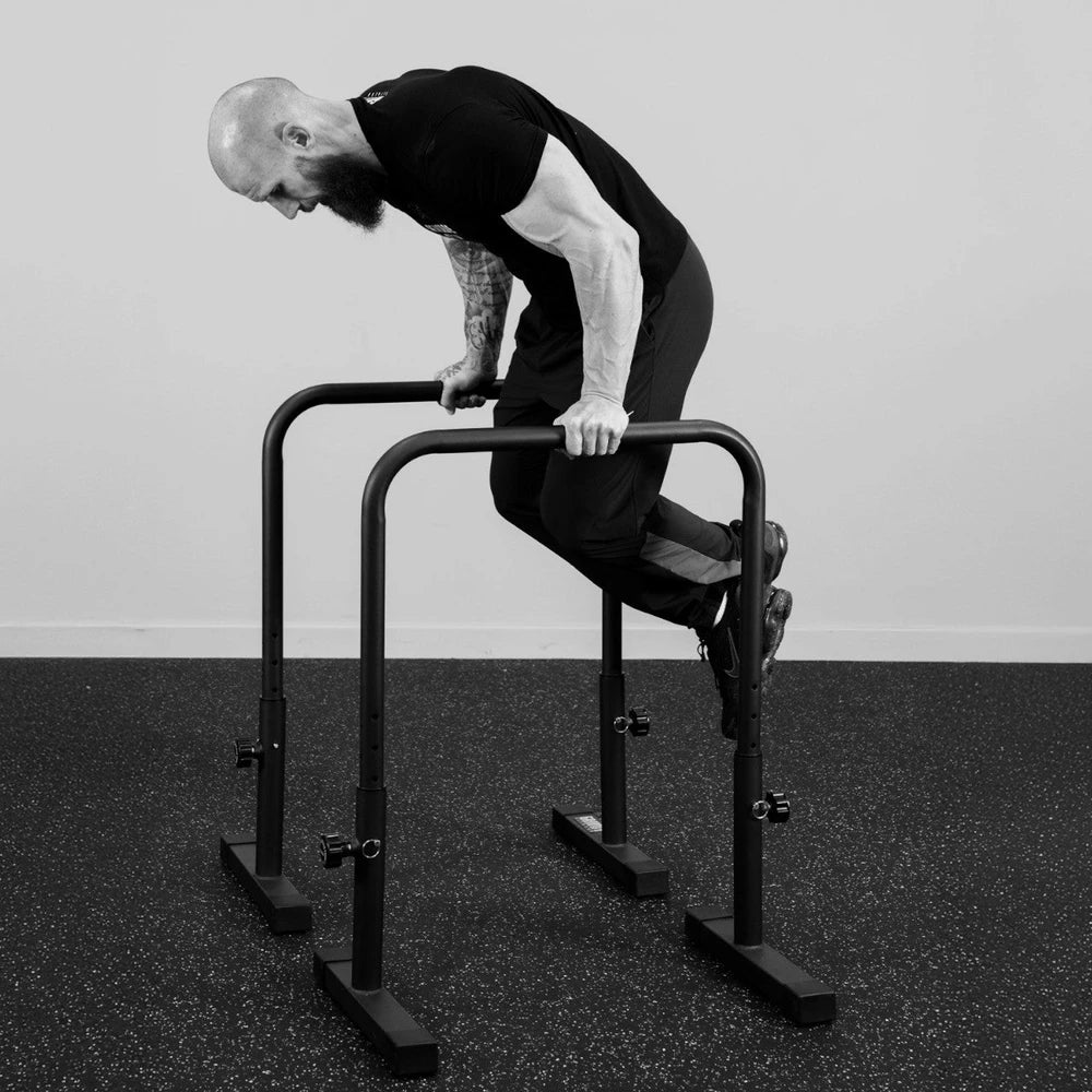 Person using a black exercise bar on a plain background