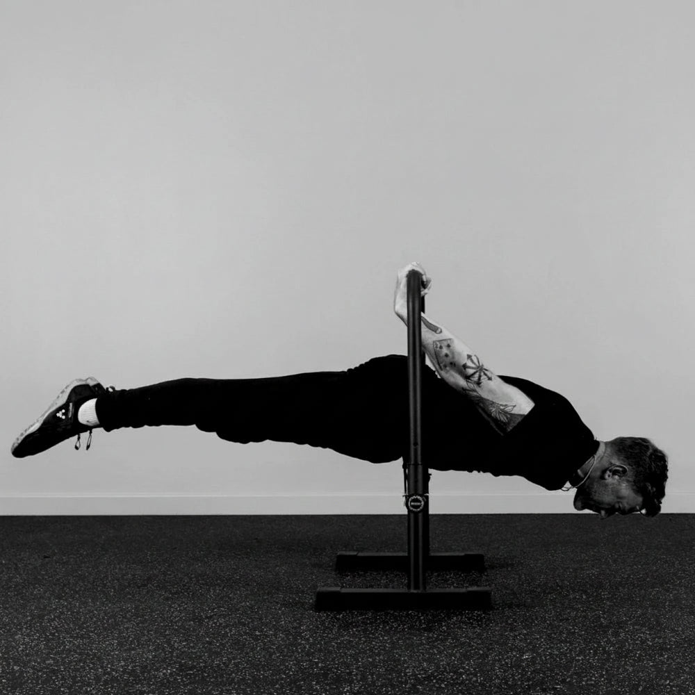 Person balancing on a push-up bar with a gray background