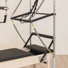 Pilates reformer machine with attachments on a beige background