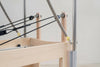 Wooden reformer with cables attached, branded on a light background