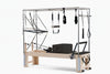 Pilates reformer with attachments on a white background