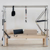 Pilates reformer machine with attachments on a white background