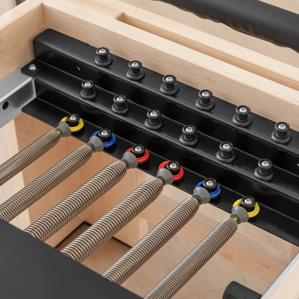 Spring bar of a pilates reformer with wooden frame detail