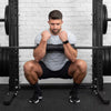 Man using a squat pad on a barbell in a gym setting