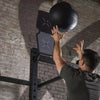 Man using a slam ball against a wall target