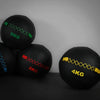 Four wall balls at different weights against a dark background