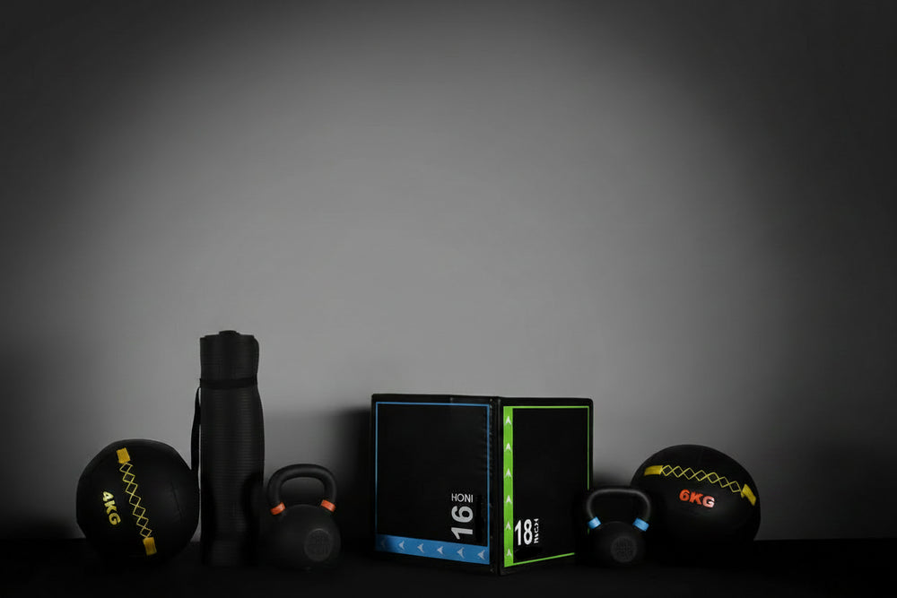 Bundle of gym equipment, kettlebells, slam balls, gym mat at gym block on a dark background