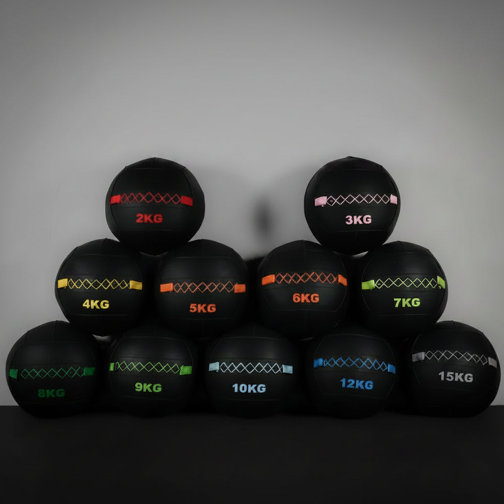 Set of weighted wall balls with weight markings on a dark background
