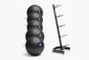 Black slam ball set in various weights and storage rack on a white background
