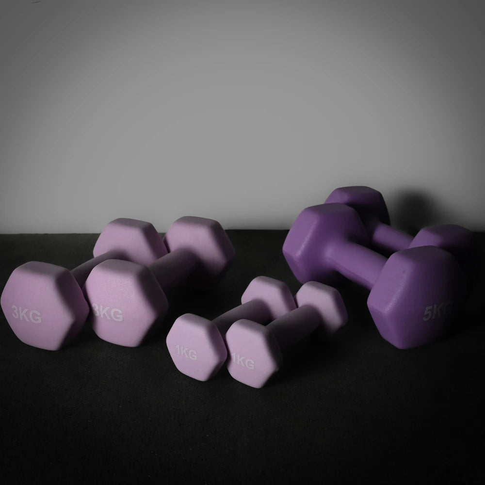 Purple dumbbells of various weights on a dark surface with a gray background