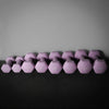 Various sized purple dumbbells on a dark surface