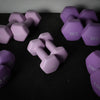 Purple weights with weight markings on a dark surface