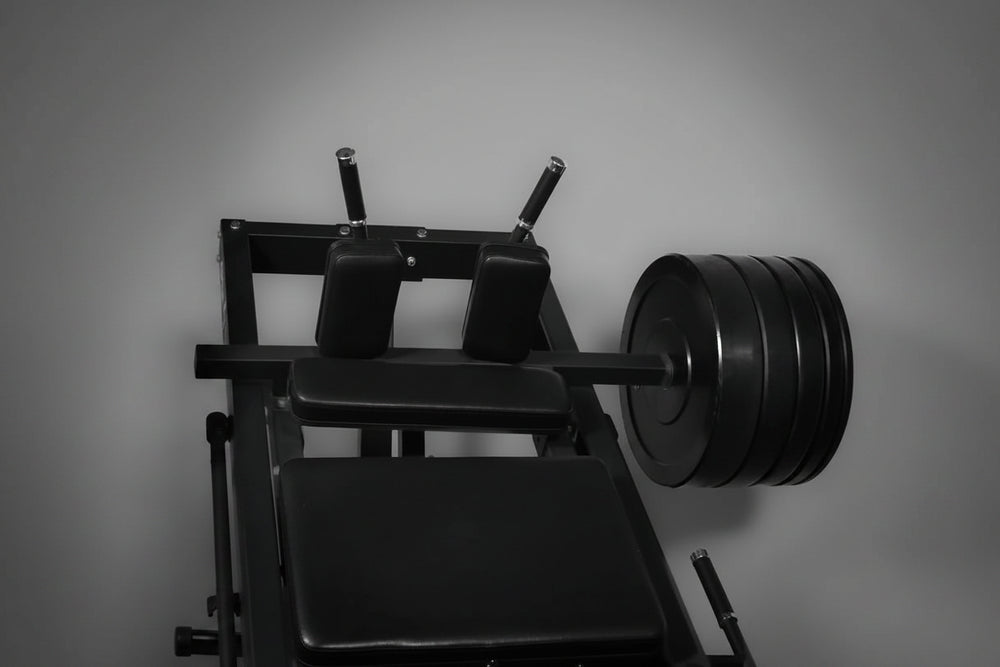 Leg press machine loaded with weight plates on a dark background