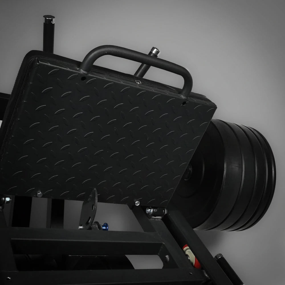 Close-up of a textured grip foot plate of a leg press hack squat machine on a gray background